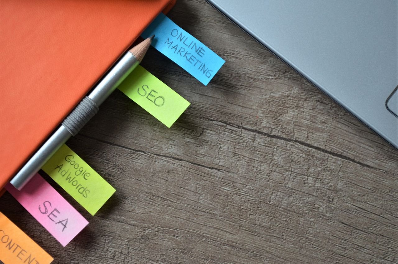 Close-up of SEO strategy planner with colorful sticky notes and a pencil on a notebook.